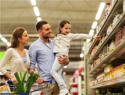 A photo of a young family grocery shopping in a supermarket.